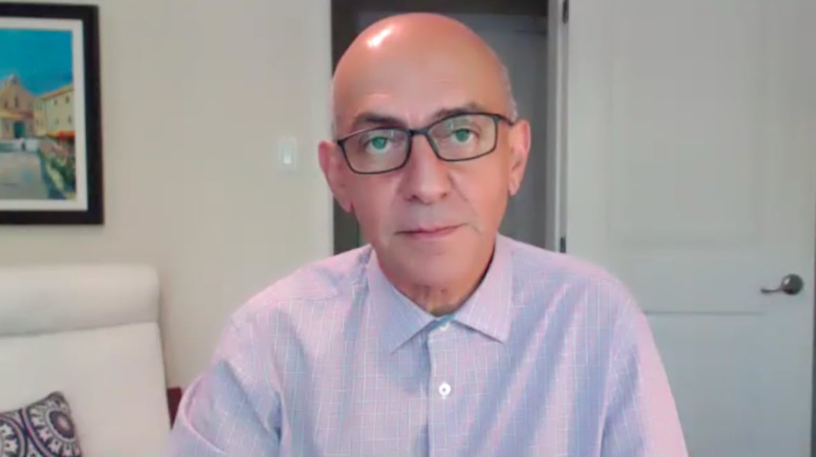A man with a disruption of the sectaar glasses looks at the camera on video call.